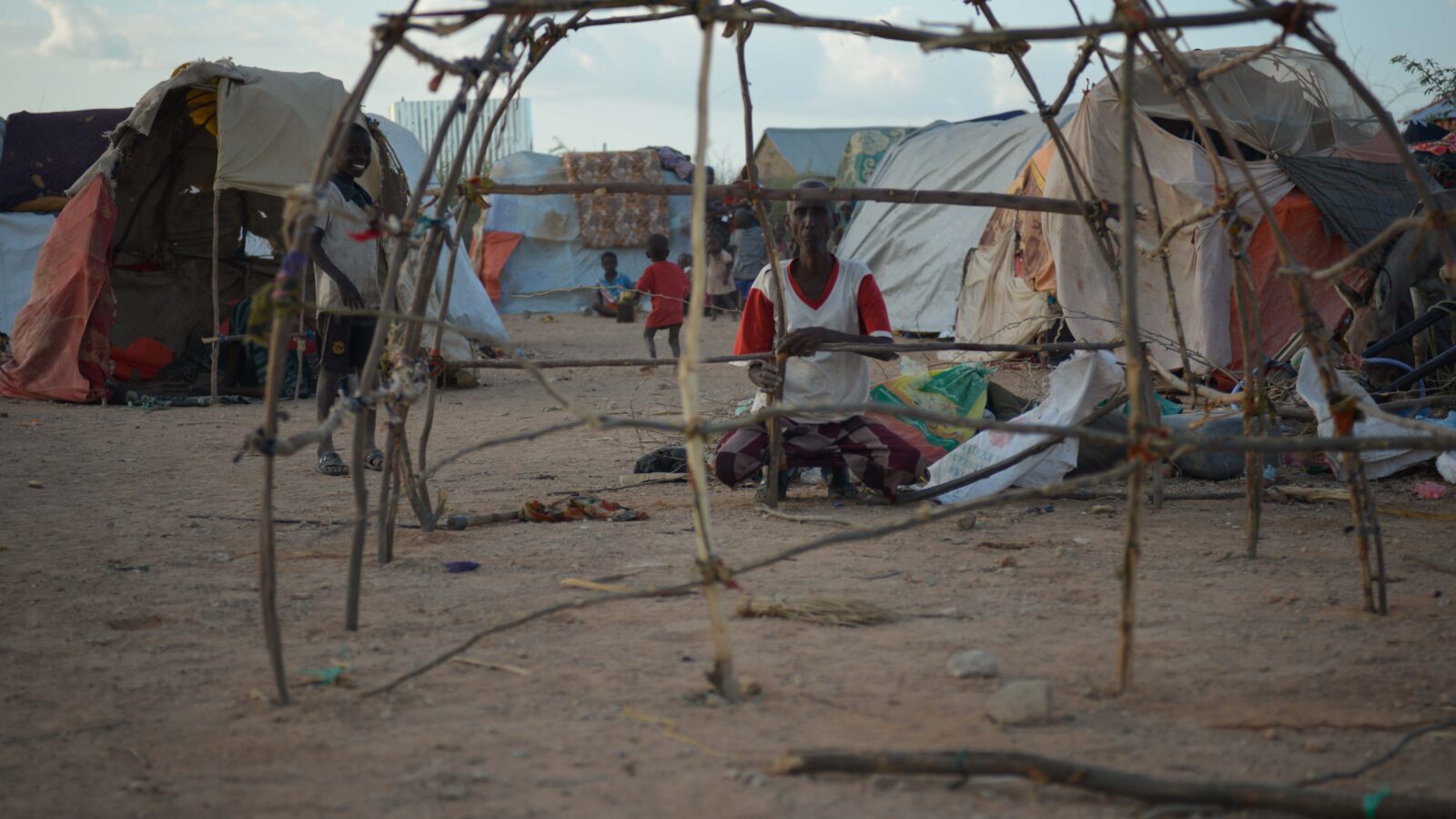 Volunteer building a temporary shelter frame