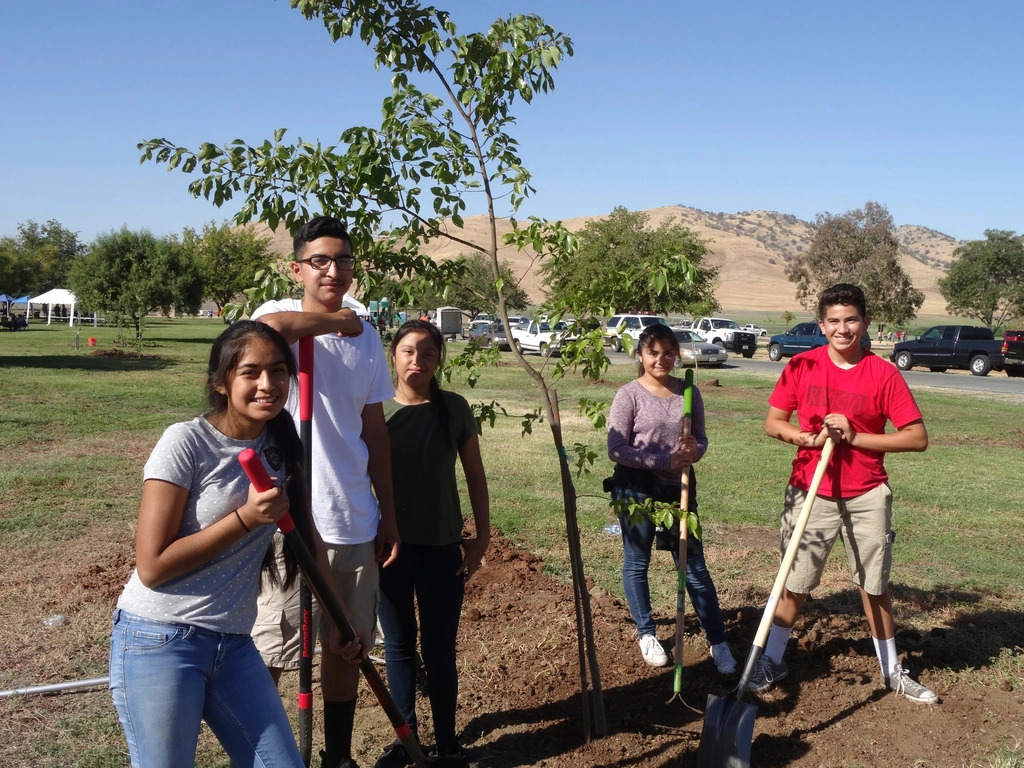A mixed-age volunteer group doing an outdoor conservation cleanup together