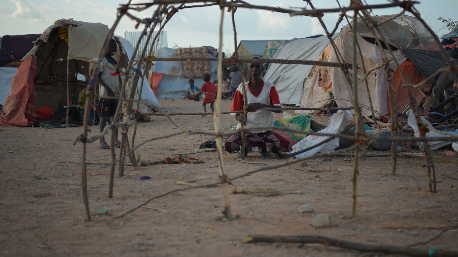 Volunteer building a temporary shelter frame
